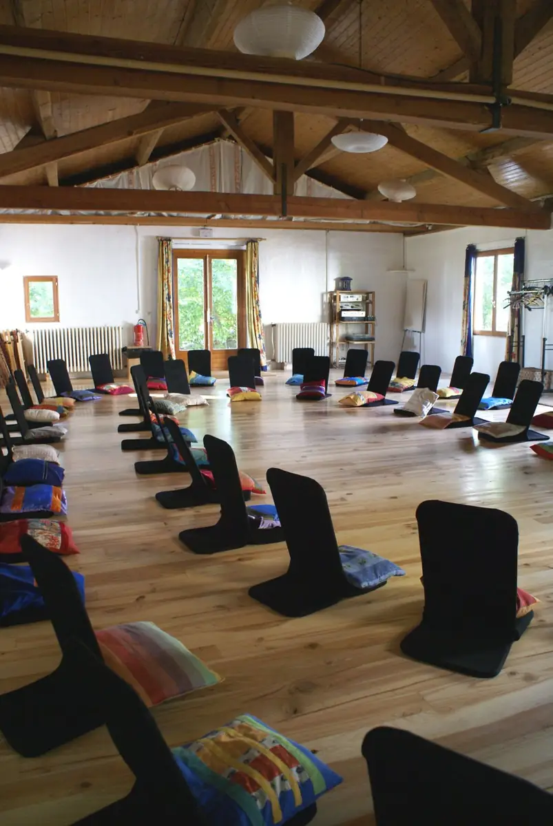 La Salle du Bas préparée pour un stage, coussins de méditation alignés sur le parquet