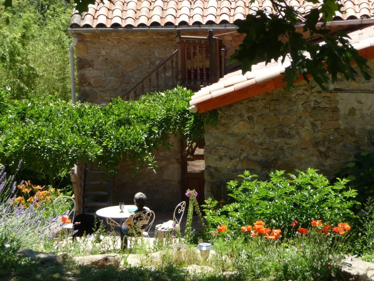 Une terrasse fleurie entre deux maisons du hameau